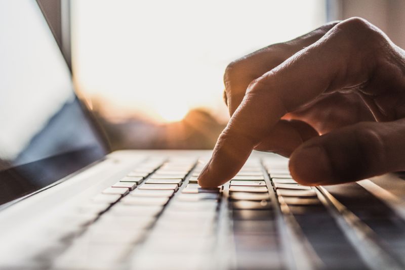 close up shot of a finger typing on a laptop keyboard