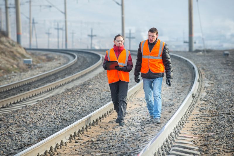 Two railroad workers walking on the tracks