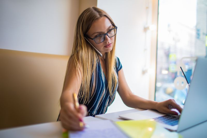 Busy woman working and writing on a notepad