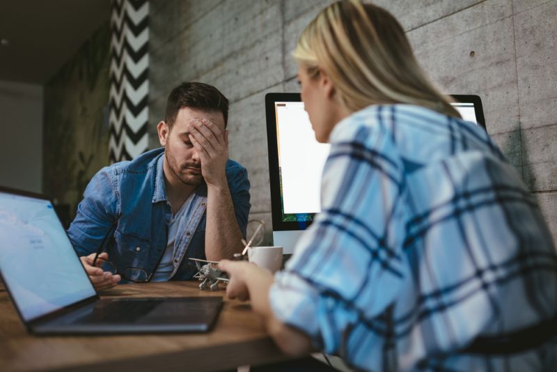 Frustrated man speaking with his coworker